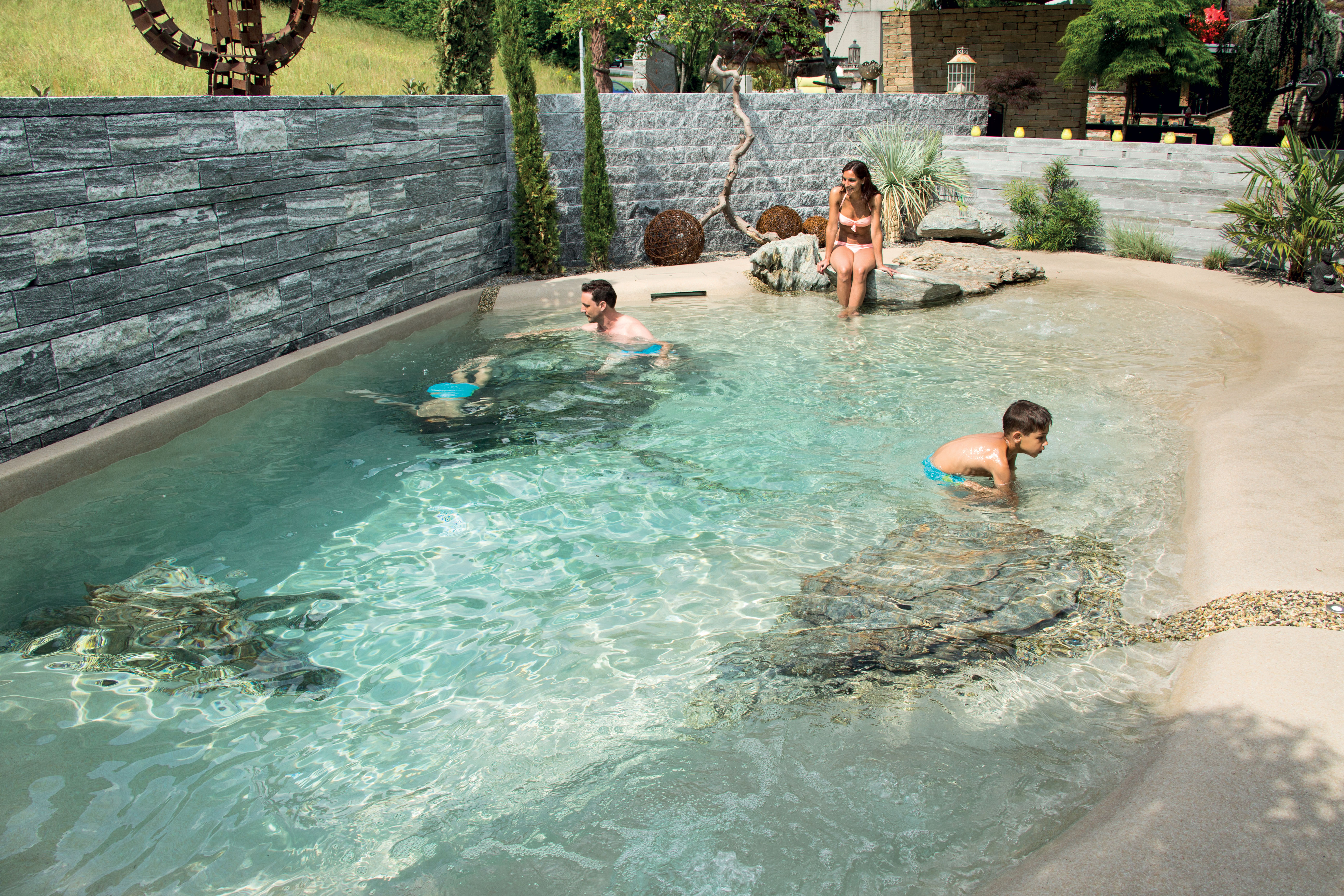 A Biodesign natural pool with organic shoreline and a stone deck in Germany