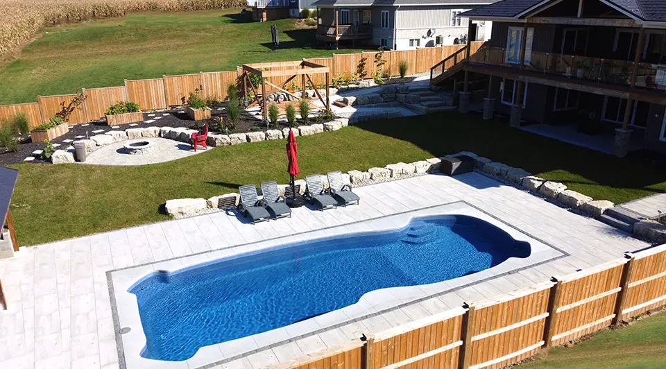 A fibreglass pool installation in Port Stanley with a clean rectangular shape and manicured surround